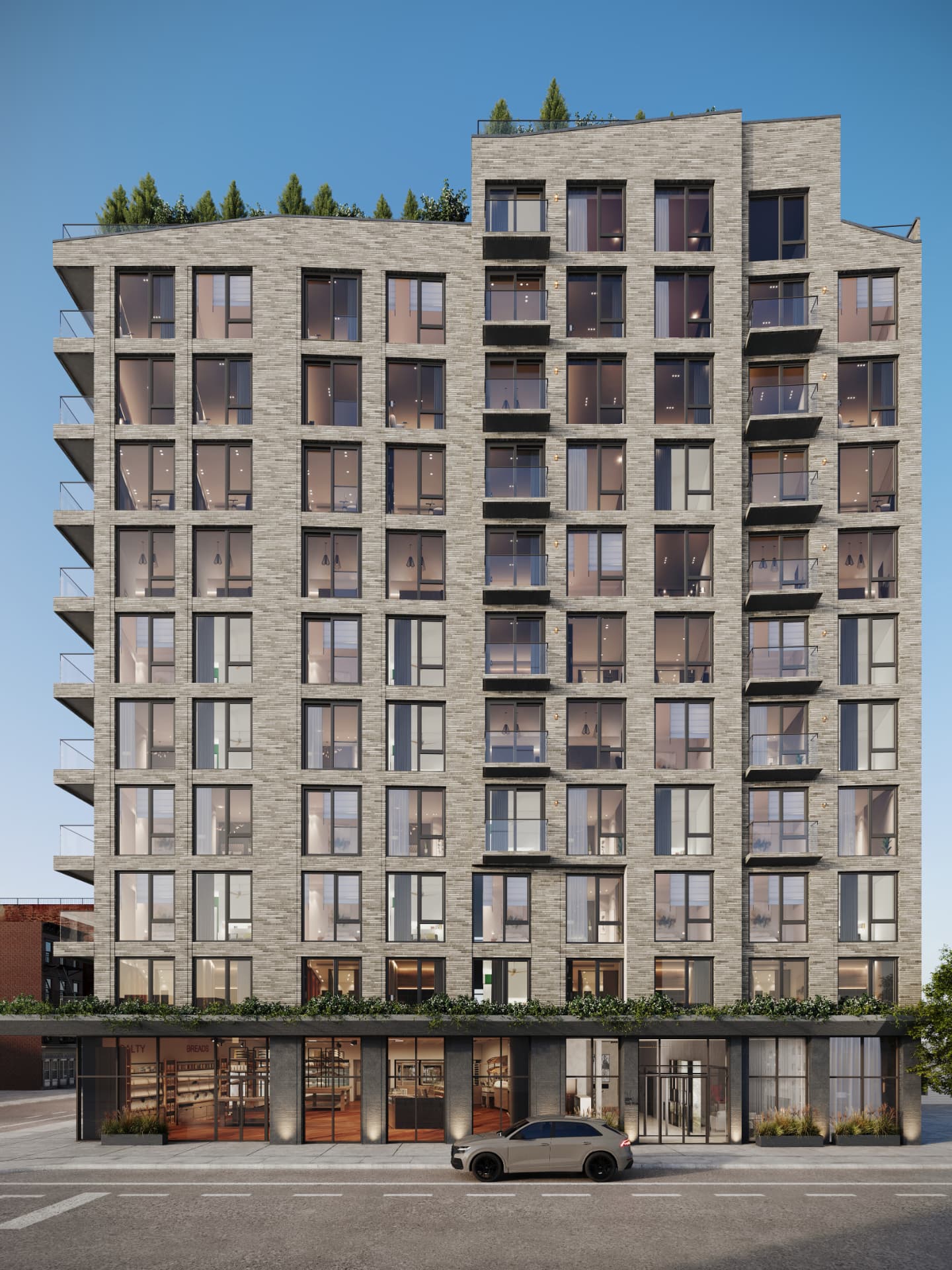 Street elevation at dusk with brick bays and ground-floor retail