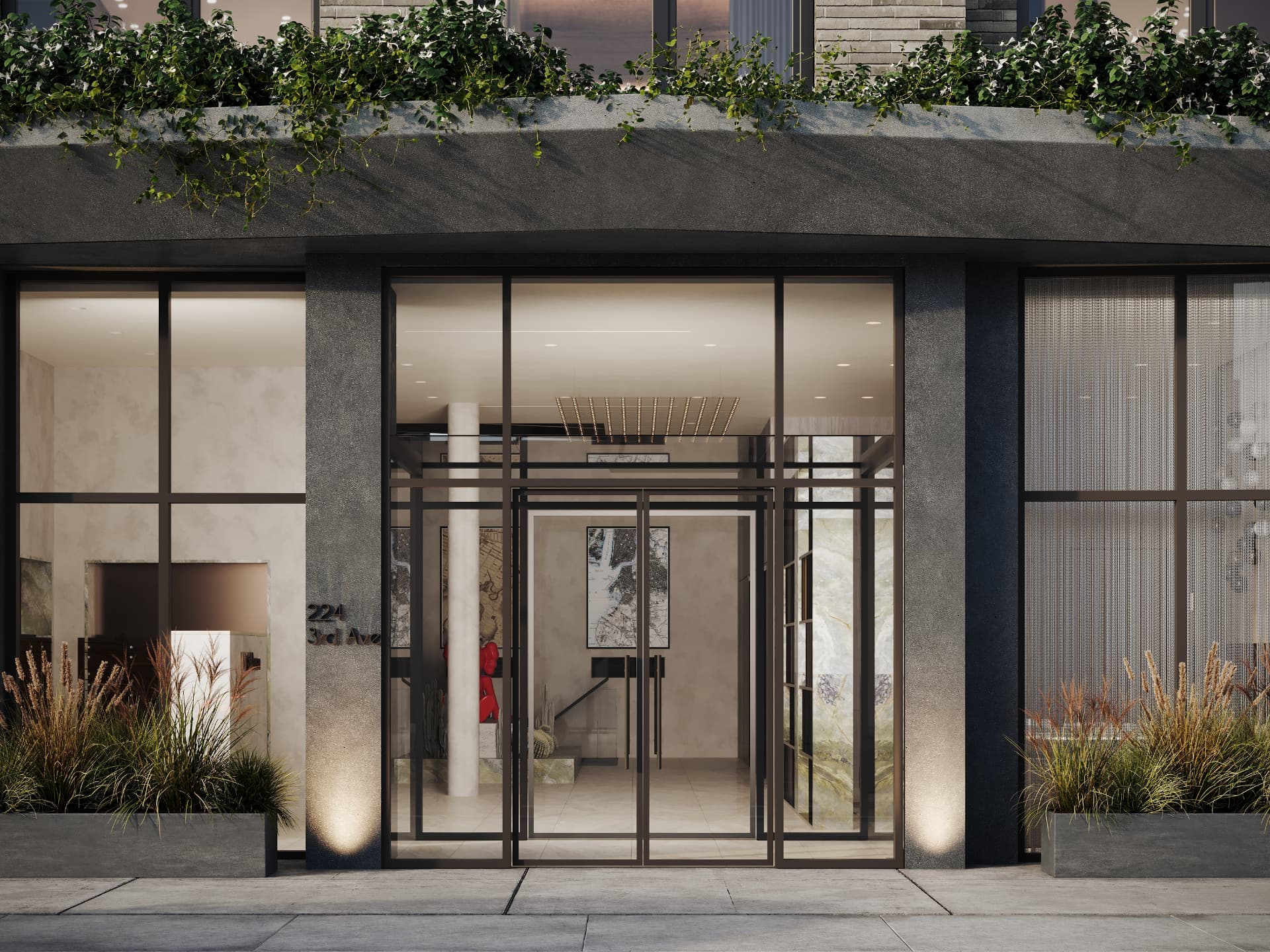Recessed entry with bronze-framed glass doors, stone walls and planting