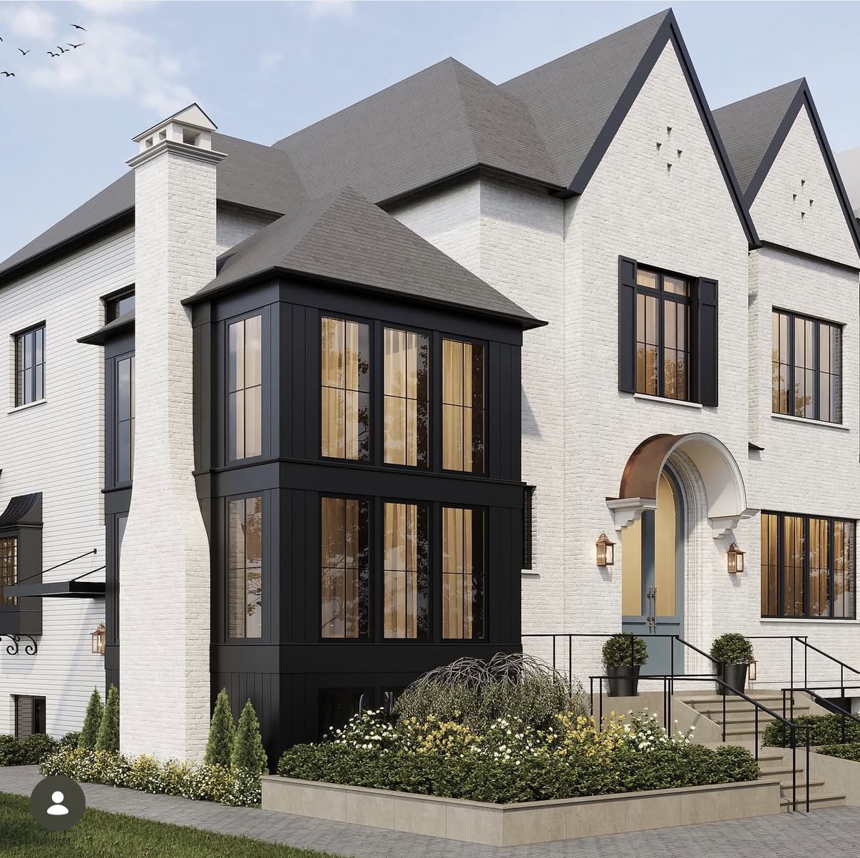 White brick facade with black steel windows and arched entry