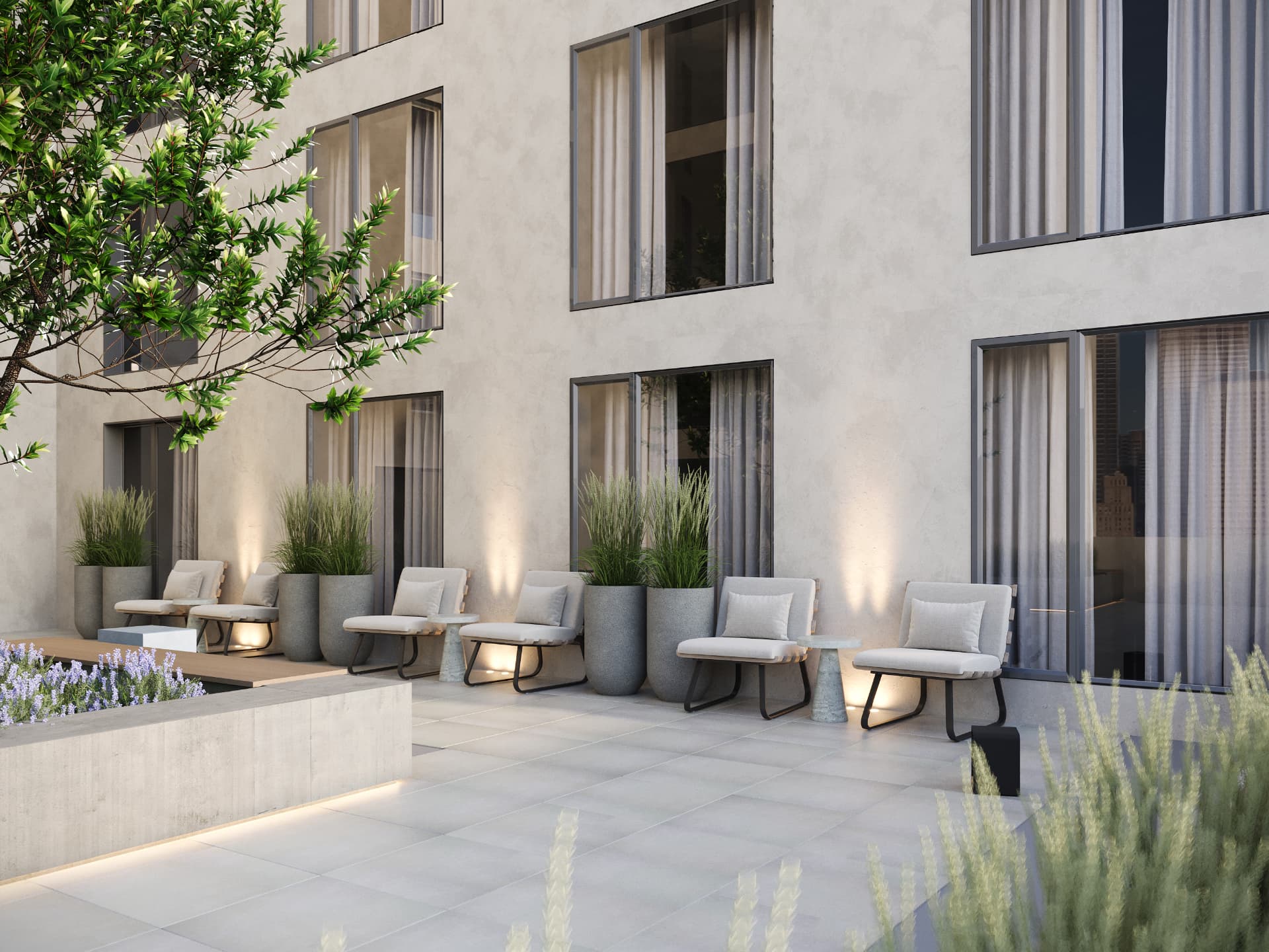 Second-floor terrace with lounge chairs, grasses and washed plaster facade
